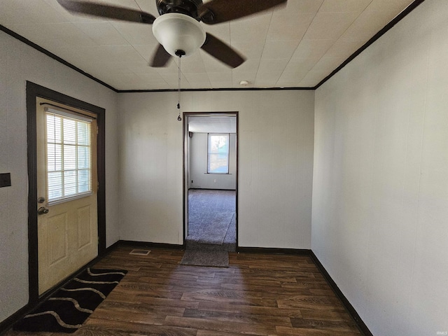 interior space with ornamental molding, ceiling fan, and dark hardwood / wood-style flooring