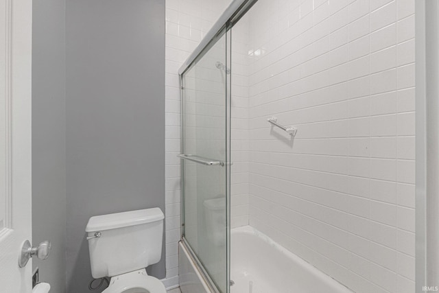 bathroom with enclosed tub / shower combo and toilet