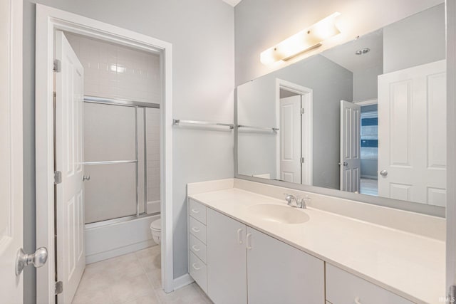 full bathroom featuring tile patterned flooring, vanity, combined bath / shower with glass door, and toilet