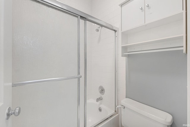 bathroom with bath / shower combo with glass door and toilet