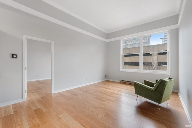 unfurnished room featuring crown molding, a baseboard heating unit, and light wood-type flooring