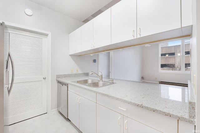 kitchen with sink, stainless steel dishwasher, white cabinets, and light stone countertops