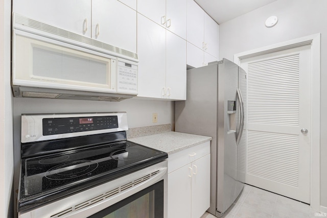 kitchen featuring stainless steel appliances, white cabinetry, light tile patterned floors, and light stone counters