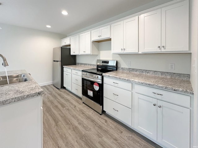 kitchen with white cabinetry, sink, stainless steel appliances, and light wood-type flooring