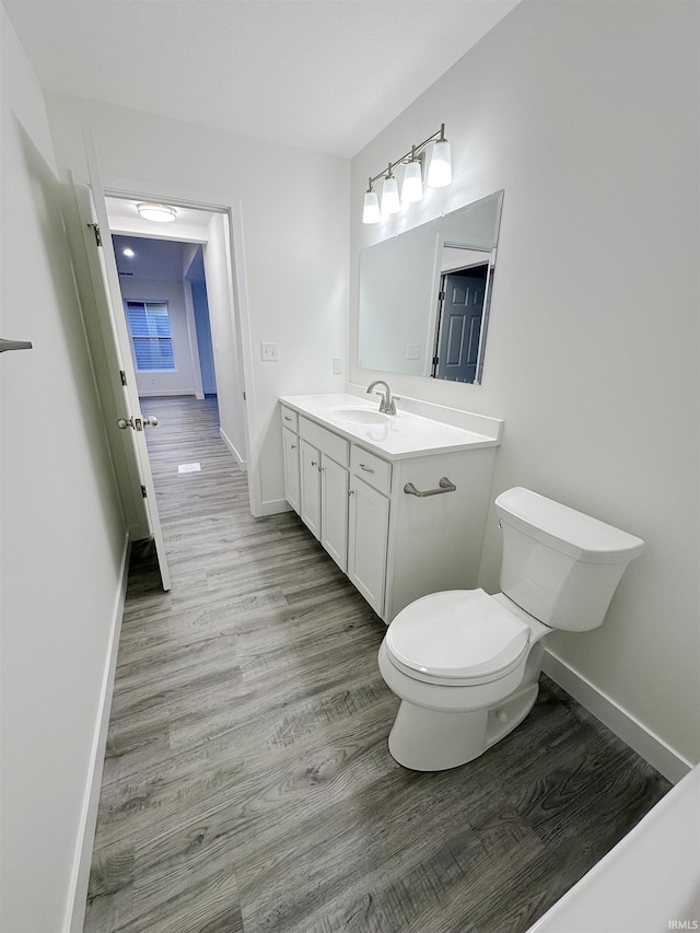 bathroom featuring hardwood / wood-style flooring, vanity, and toilet