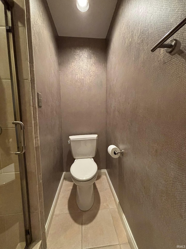 bathroom with toilet, an enclosed shower, and tile patterned flooring