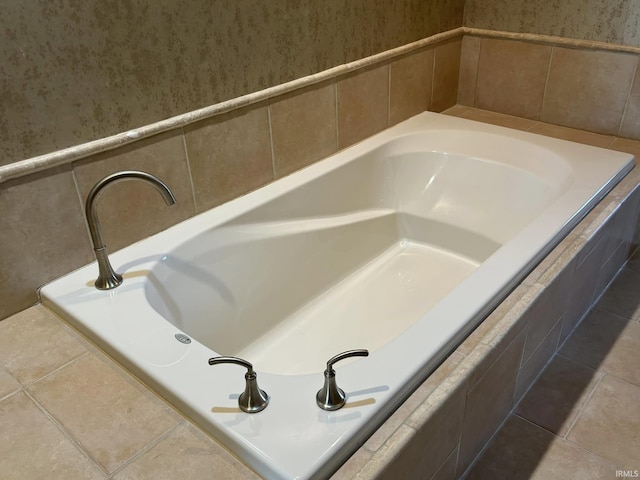 bathroom with a relaxing tiled tub and tile patterned floors