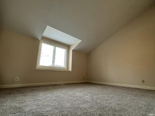 bonus room with vaulted ceiling and carpet floors