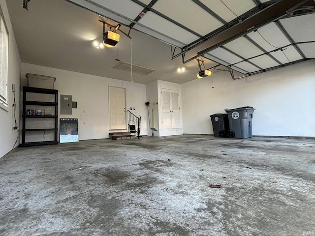 garage with a garage door opener and electric panel