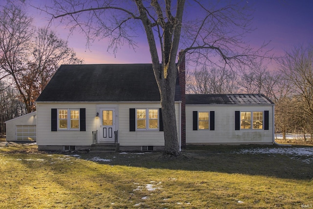 cape cod-style house featuring a lawn