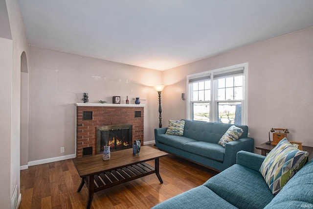 living room featuring a brick fireplace and hardwood / wood-style floors