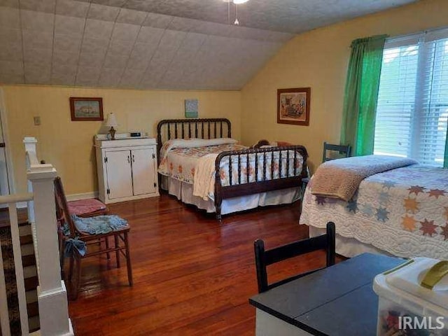 bedroom featuring lofted ceiling and dark hardwood / wood-style floors