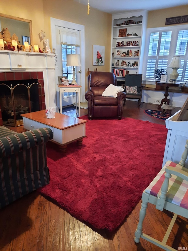 living room featuring a tiled fireplace and a healthy amount of sunlight