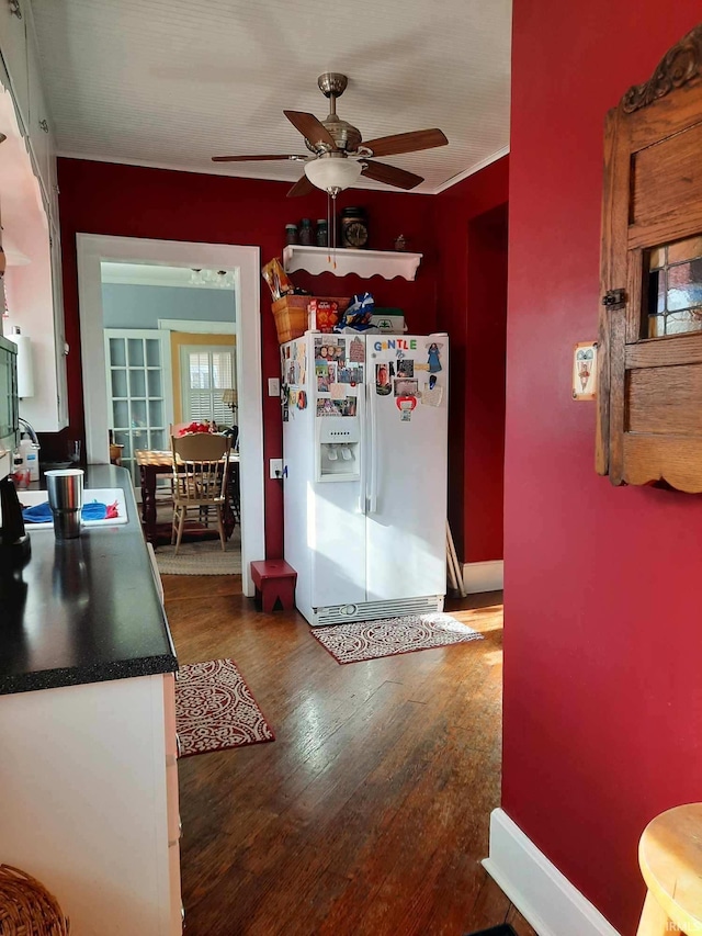 kitchen with ceiling fan, dark hardwood / wood-style flooring, and white fridge with ice dispenser