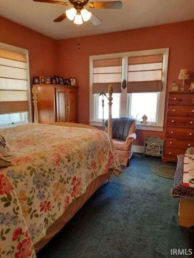 bedroom featuring ceiling fan and dark carpet