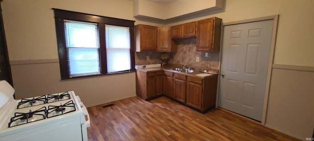 kitchen with sink, white range with gas cooktop, and dark wood-type flooring