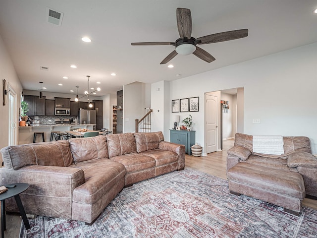 living room featuring light hardwood / wood-style flooring and ceiling fan