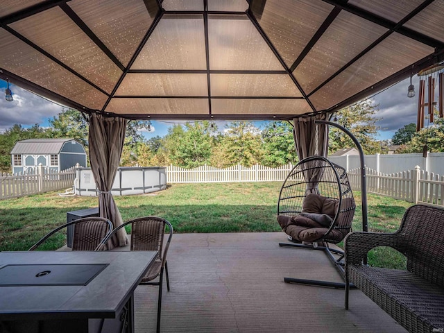 view of patio / terrace featuring a fenced in pool and a gazebo