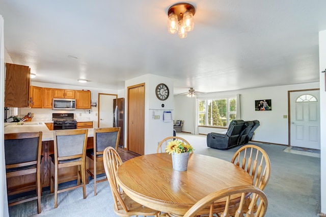 dining space featuring ceiling fan and sink