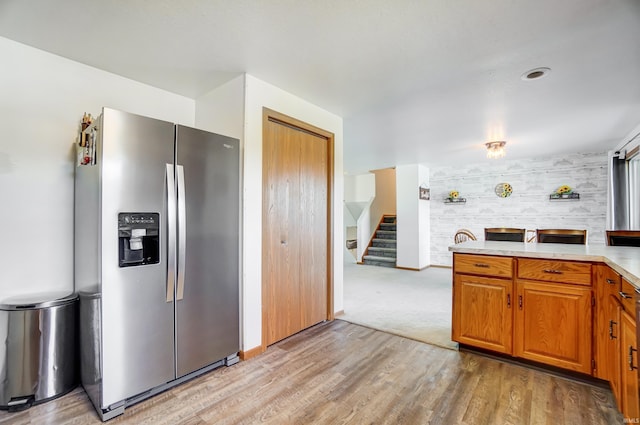 kitchen featuring light wood-type flooring and stainless steel fridge with ice dispenser