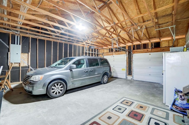 garage with a garage door opener, electric panel, and white refrigerator