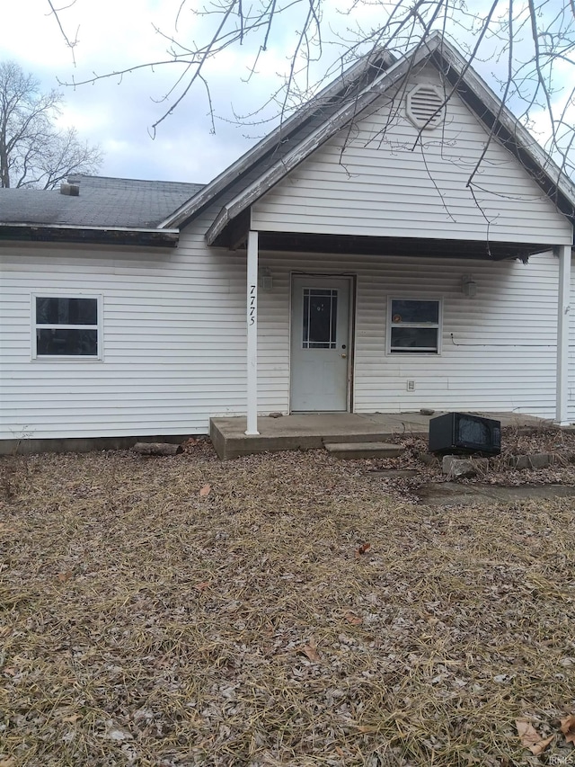 back of property featuring covered porch