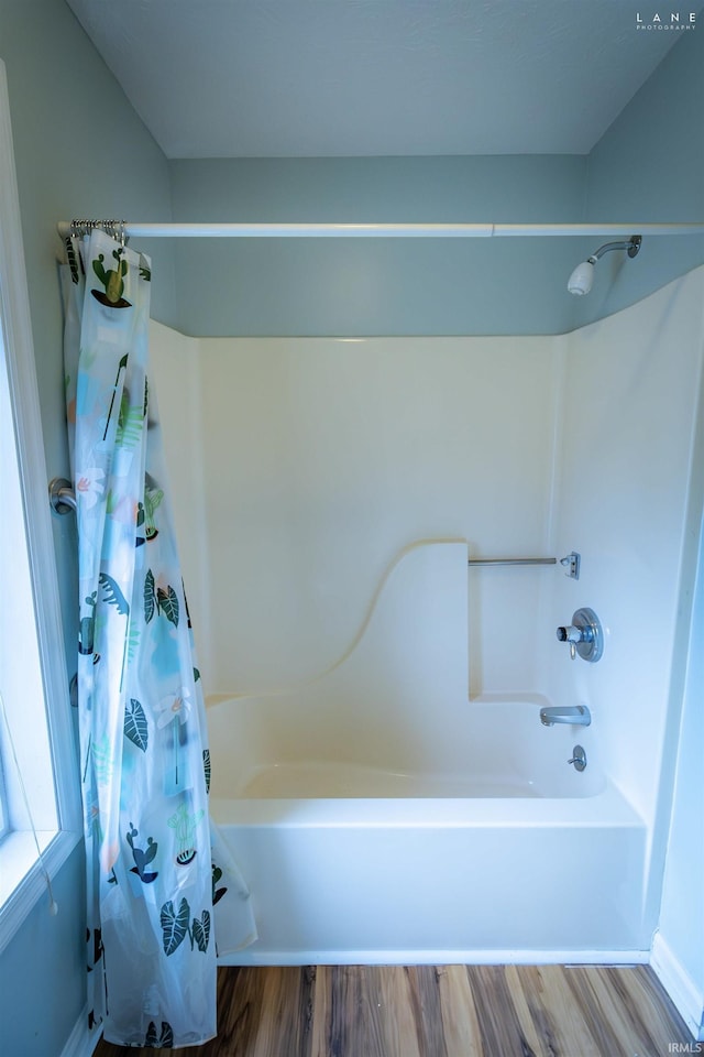 bathroom with hardwood / wood-style floors and shower / tub combo with curtain