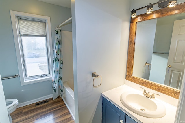 full bathroom featuring wood-type flooring, toilet, shower / tub combo, and vanity