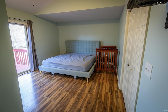 bedroom featuring lofted ceiling, dark hardwood / wood-style floors, and access to outside