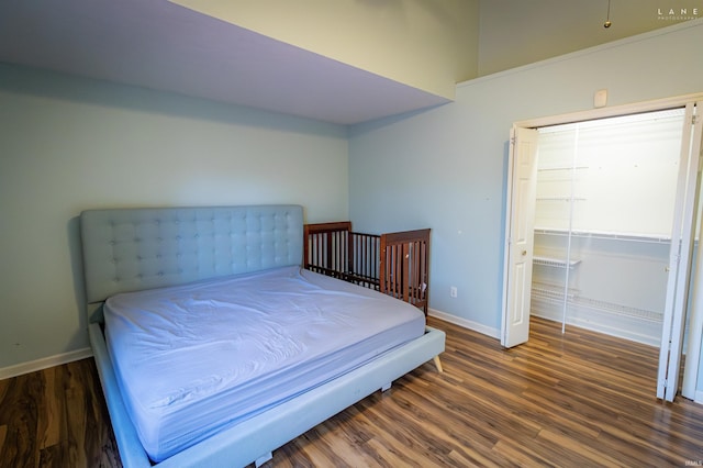 bedroom with dark hardwood / wood-style flooring and a closet