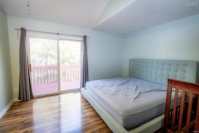 bedroom with hardwood / wood-style flooring, lofted ceiling, access to exterior, and a textured ceiling