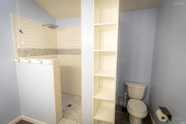 bathroom with tiled shower and toilet