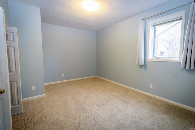 carpeted spare room featuring a textured ceiling