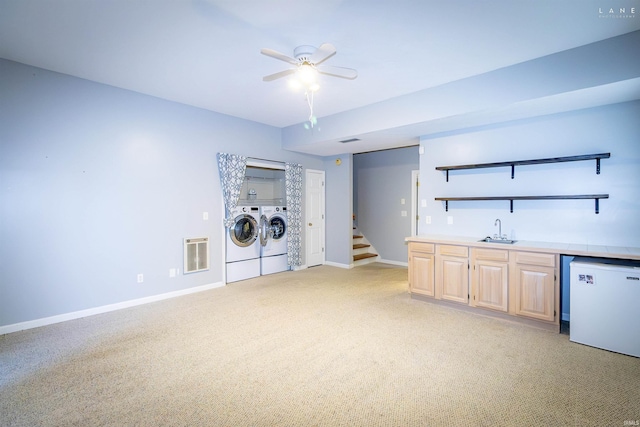 washroom featuring washing machine and dryer, light carpet, indoor wet bar, and ceiling fan