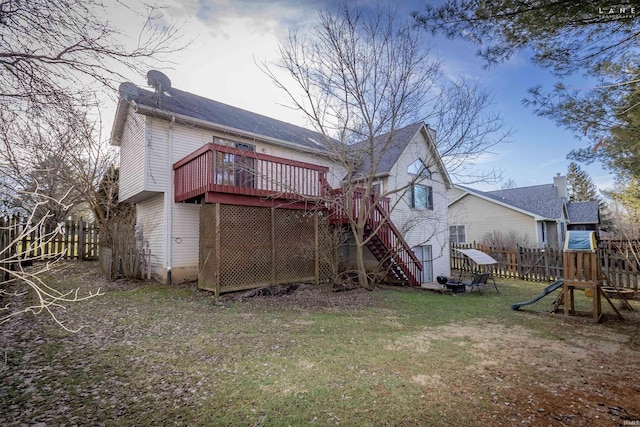 back of house featuring a yard, a deck, and a playground