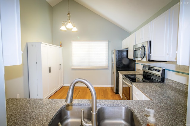 kitchen featuring sink, appliances with stainless steel finishes, white cabinetry, hanging light fixtures, and light wood-type flooring