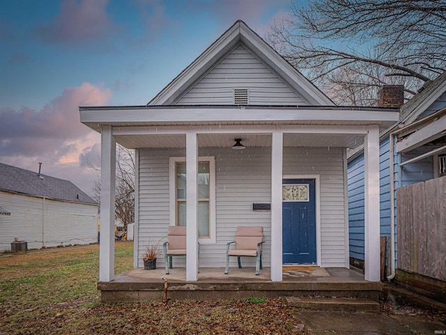 exterior entry at dusk featuring central AC and covered porch