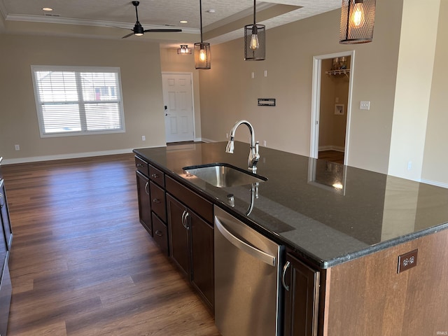 kitchen with sink, dark stone countertops, stainless steel dishwasher, an island with sink, and pendant lighting