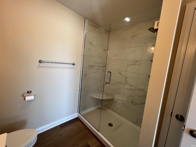 bathroom featuring toilet, an enclosed shower, and hardwood / wood-style floors