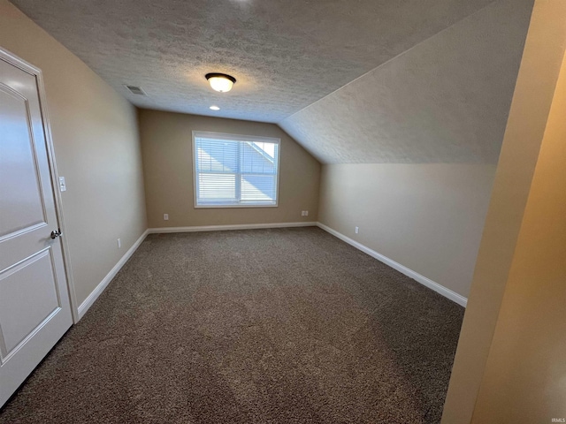 additional living space featuring lofted ceiling, carpet, and a textured ceiling