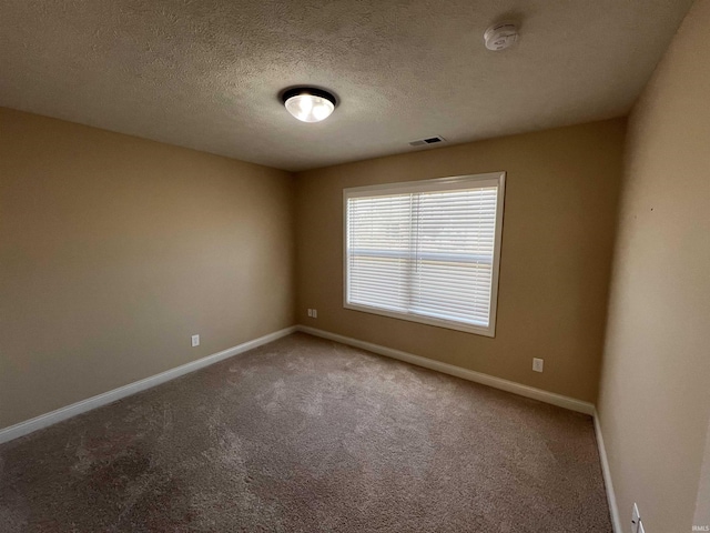 spare room featuring carpet floors and a textured ceiling