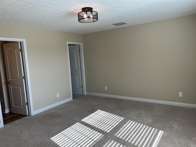 carpeted empty room with a textured ceiling