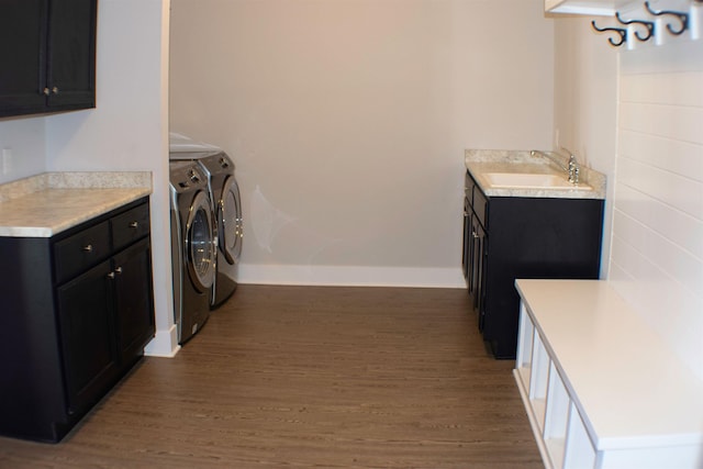 laundry room with washer and dryer, sink, cabinets, and dark hardwood / wood-style floors