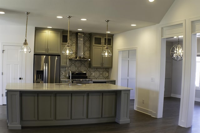 kitchen with sink, tasteful backsplash, stainless steel appliances, a kitchen island with sink, and wall chimney range hood