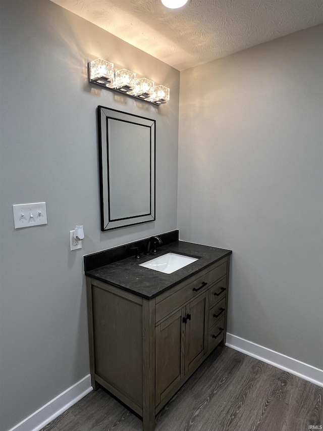 bathroom featuring vanity, hardwood / wood-style flooring, and a textured ceiling