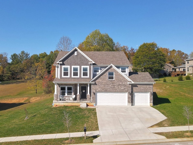 craftsman-style house featuring a garage, a front yard, and covered porch