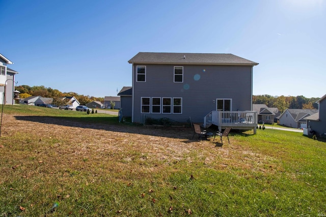 rear view of house featuring a yard and a deck