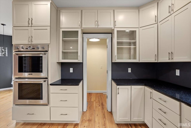 kitchen featuring white cabinetry, double oven, and light hardwood / wood-style flooring