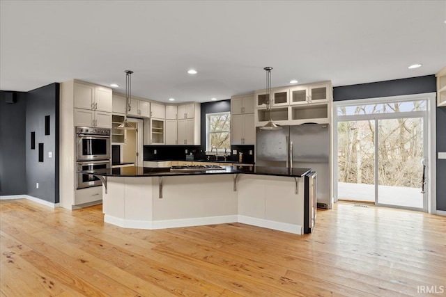 kitchen featuring sink, decorative light fixtures, stainless steel appliances, and a center island