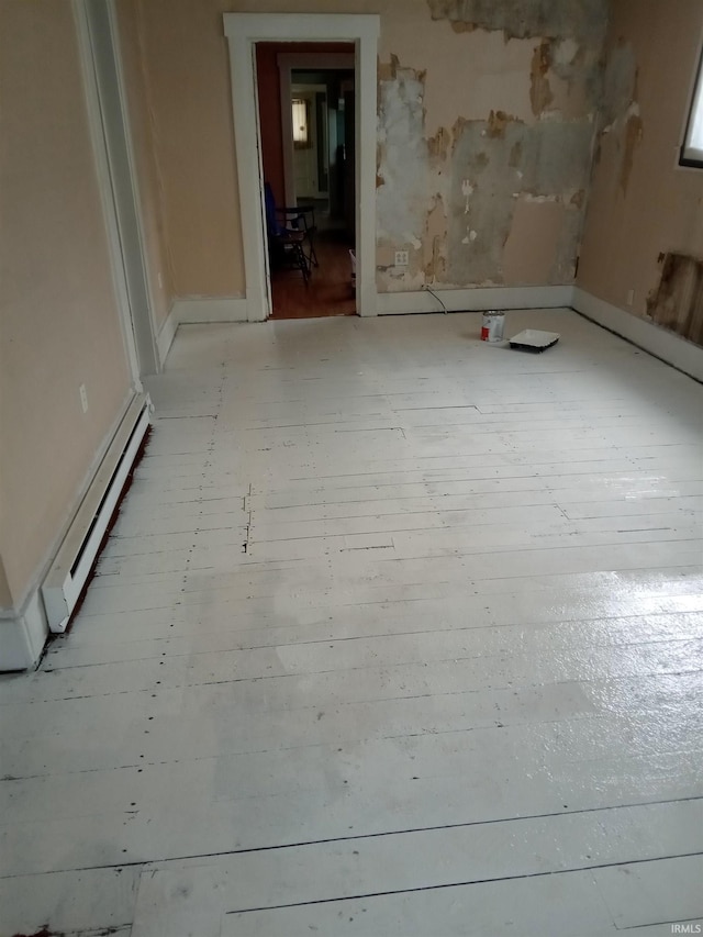 unfurnished room featuring a baseboard radiator and light wood-type flooring